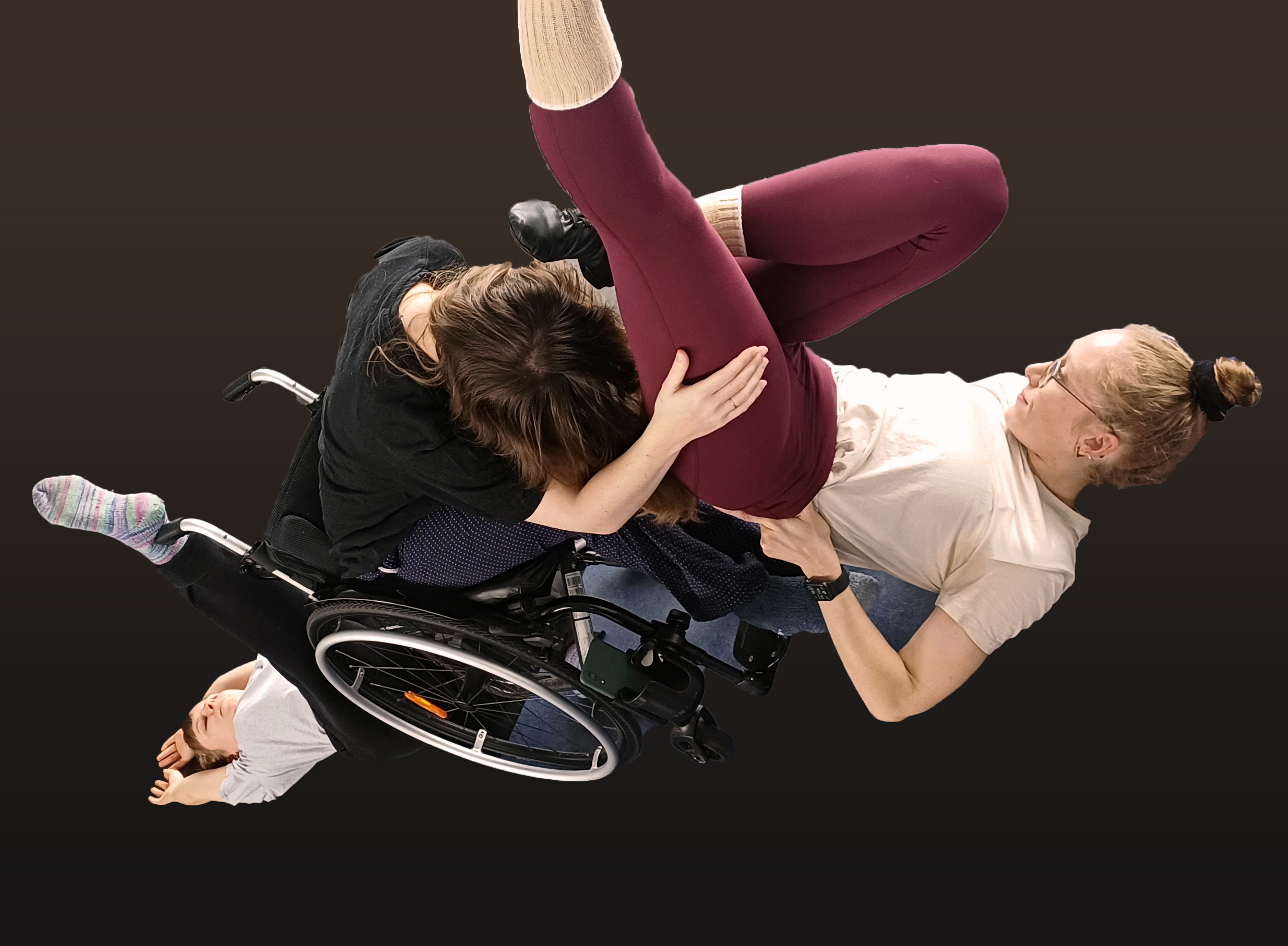 Una persona en silla de ruedas y otra subida encima de la persona en sillas haciendo una figura de danza