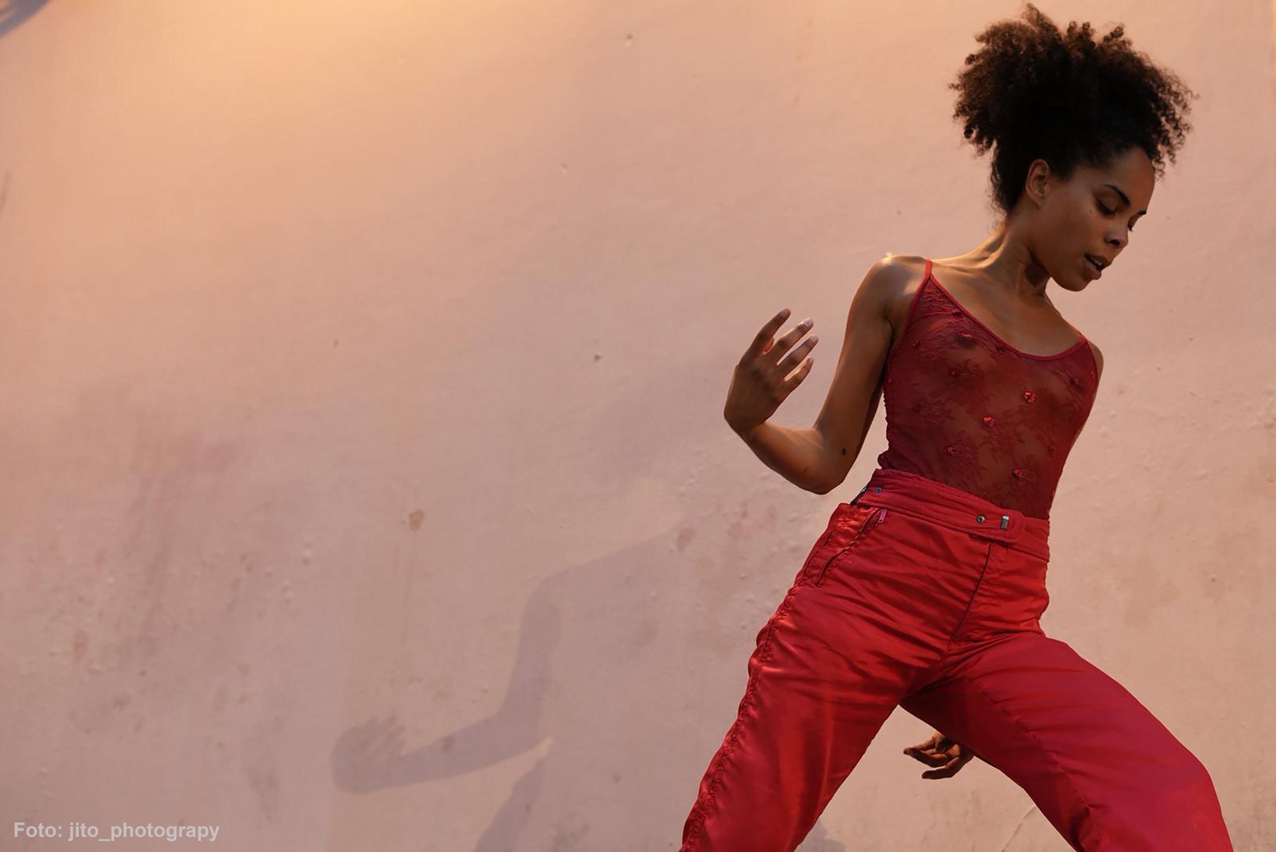 Foto de escena. Una chica vestida de rojo bailando